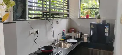 a small kitchen with a sink and a refrigerator at Gangadharam Tiny House 2BHK AC in Tellicherry