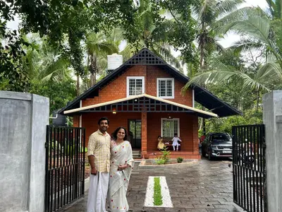 a man and a woman standing in front of a house at Gangadharam Tiny House 2BHK AC in Tellicherry