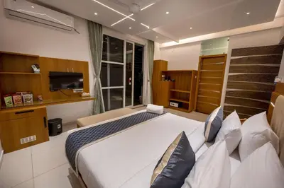 a bedroom with a large bed and a television at S R Pool Suites in Mysore