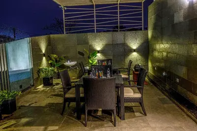 a table and chairs on a patio at night at S R Luxury Stays in Mysore