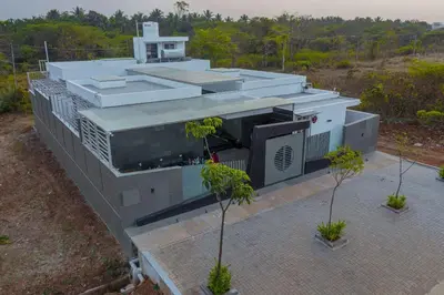 a concrete building with trees in front of it at S R Luxury Stays in Mysore