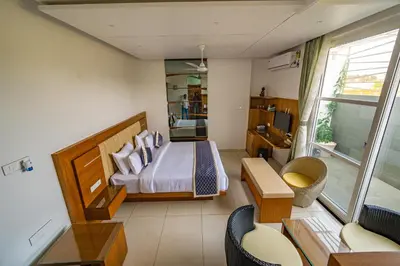 a bedroom with a bed and a living room at S R Premium Suites in Mysore