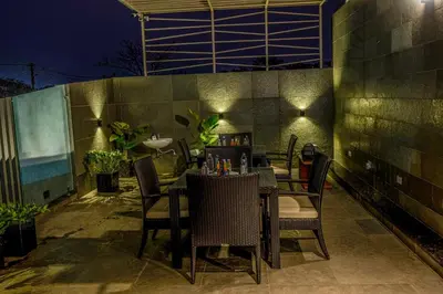 a table and chairs on a patio at night at S R Spa Suites in Mysore