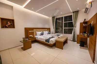 a bedroom with a bed and a tv and a window at S R Spa Suites in Mysore