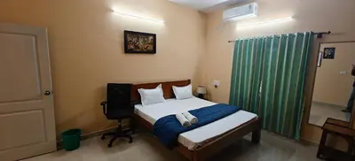 a bedroom with a bed and a green curtain at S R Villa Mysore in Mysore