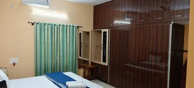 a bedroom with a bed and a green curtain at S R Villa Mysore in Mysore