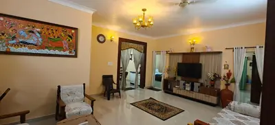 a living room with a couch and a tv at S R Villa Mysore in Mysore