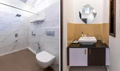a white bathroom with a toilet and a sink at Treebo Premium Cochin Airport, 5 min From Cochin Airport in Ernakulam