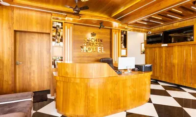 a reception desk in a hotel lobby with a checkered floor at Treebo Premium Cochin Airport, 5 min From Cochin Airport in Ernakulam