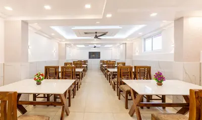 a row of tables and chairs in a room at Treebo Premium Cochin Airport, 5 min From Cochin Airport in Ernakulam