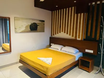 a bedroom with a bed with a yellow bedspread at Heaven Hills resorts in Vythiri