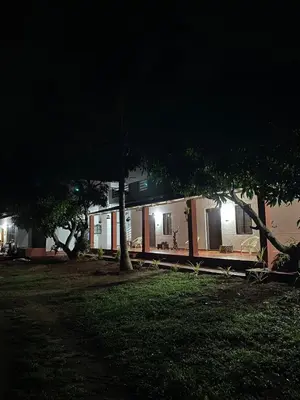 a building with lights on in a park at night at Aastha homestay in Mysore
