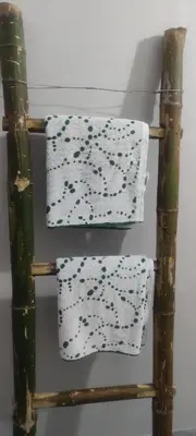 two towels on a bamboo shelf in a room at Aastha homestay in Mysore