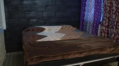 a bed in a room with a brick wall at Wild Tusker Homestay Masinagudi by LexStays in Masinagudi
