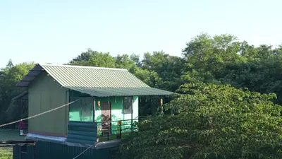 a small green house with a metal roof at Wild Tusker Homestay Masinagudi by LexStays in Masinagudi