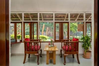 a room with two chairs and a table and windows at The Anexure - Great Estate Stay for Remote Work in Siddapur