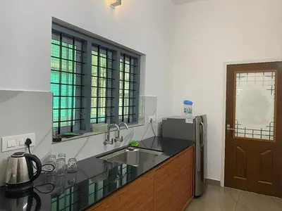 a kitchen with a sink and a counter top at Crystal Riverview Homestay in Kuttampuzha