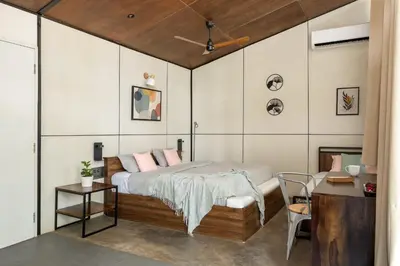 a bedroom with a bed with pink pillows at Cove by Raho - Nestled Away Retreat in Siddapur