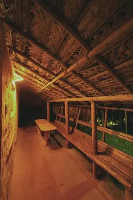two benches sitting inside of a building with a roof at The Soul Marayoor Mudhouse - Munnar in Marayoor