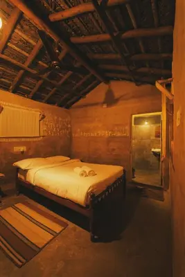 a bedroom with a large bed in a room at The Soul Marayoor Mudhouse - Munnar in Marayoor