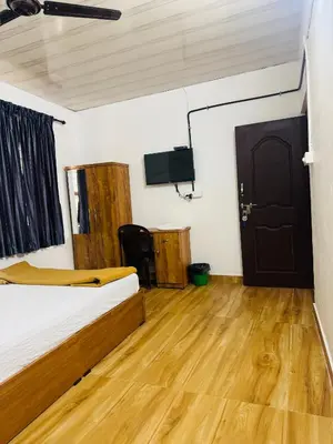 a bedroom with a bed and a flat screen tv at Mountain valley in Attappādi