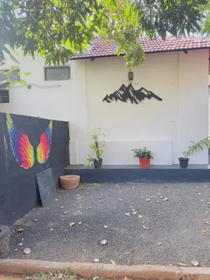 a house with a painting on the side of it at Mountain valley in Attappādi