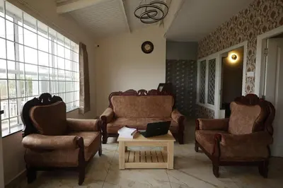 a living room with two couches and a coffee table at Haze cottage- MA Cottage in Ooty