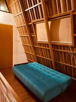 a blue bench in a room with wooden shelves at Hill View 'A'Frame Villa Wayanad in Vythiri