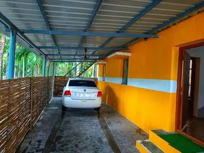 a white car parked in a parking lot at Coconut Grove villa by Shivalaya Stays in Alāndurai