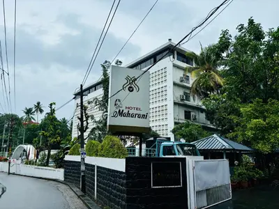 a building with a sign in front of it at Maharani Hotel in Kozhikode