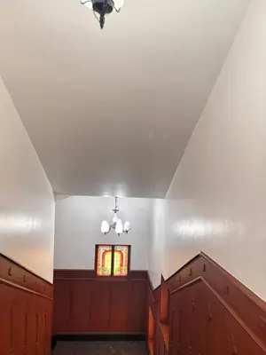 an attic hallway with a window and wooden cabinets at Maharani Hotel in Kozhikode