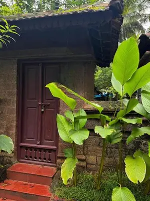 a house with a red door and a plant at Illam Heritage inn Bungalow l 4 BHK in Guruvāyūr