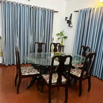 a dining room with a glass table and chairs at Illam Heritage inn Bungalow l 4 BHK in Guruvāyūr