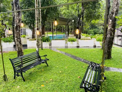 a swing in the grass in a park at The Hive at Druv Dakshin Farm Resort in Padinjarathara
