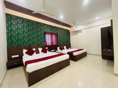 a bedroom with two beds and a green wallpaper at My Rooms Channapatna in Channapatna