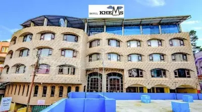a large brick building with a sign on it at Devi Enterprises - Hotel Khems in Ooty