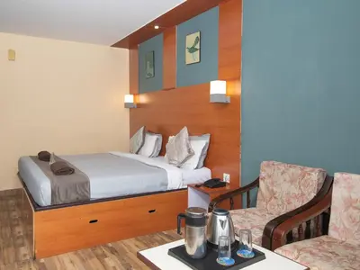 a hotel room with a bed and a chair at Devi Enterprises - Hotel Khems in Ooty
