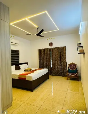 a bedroom with a bed and a ceiling fan at Diamond Villa Near Rajagiri Hospital in Alwaye