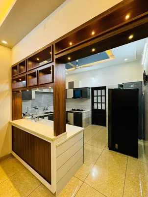 a large kitchen with a black refrigerator in it at Diamond Villa Near Rajagiri Hospital in Alwaye