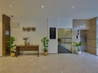 a lobby with a table and potted plants at Grand Continent Mysore A Sarovar Portico Affiliate Hotel in Mysore