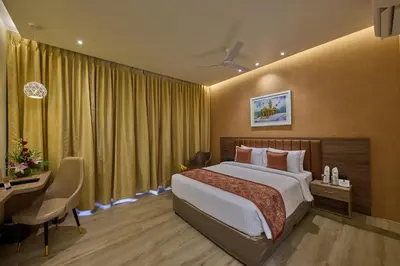 a hotel room with a bed and a desk and a desk at Grand Continent Mysore A Sarovar Portico Affiliate Hotel in Mysore