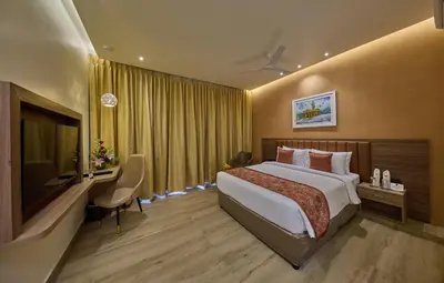 a hotel room with a bed and a television at Grand Continent Mysore A Sarovar Portico Affiliate Hotel in Mysore