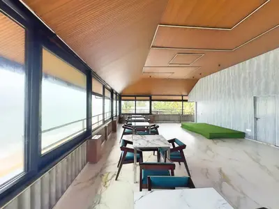 a row of tables and chairs in a room with windows at The Cabana in Cherai Beach