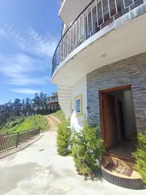 a building with a balcony on top of it at Valley homes in Ooty