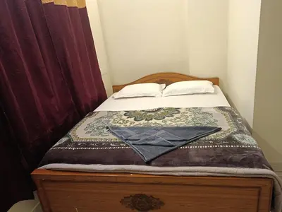a small bedroom with a bed with a blanket on it at Abbu Royal Palace Cottage in Ooty