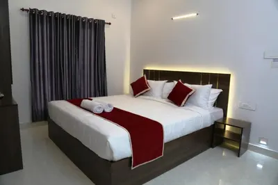 a bedroom with a large bed with red and white pillows at Le Sancta homestay in Marayoor