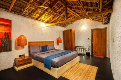 a bedroom with a bed and a wooden ceiling at Kudisai Marayoor - Munnar in Munnar