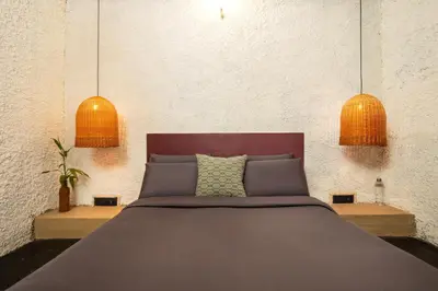 a bedroom with a bed with two pendant lights at Kudisai Marayoor - Munnar in Munnar