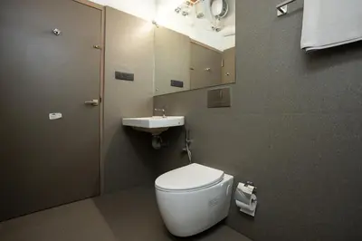 a bathroom with a white toilet and a sink at Kudisai Marayoor - Munnar in Munnar
