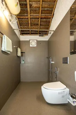 a bathroom with a toilet and a shower at Kudisai Marayoor - Munnar in Munnar